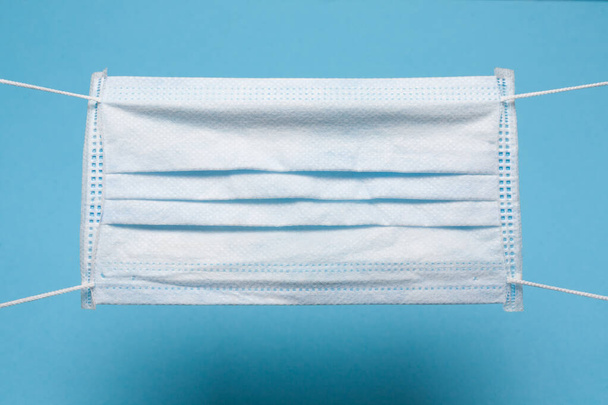 Medical mask, Medical protective mask on blue background with empty space. Disposable surgical mask. Healthcare medical Coronavirus,  covid-19 quarantine, hygiene concept. - Photo, Image