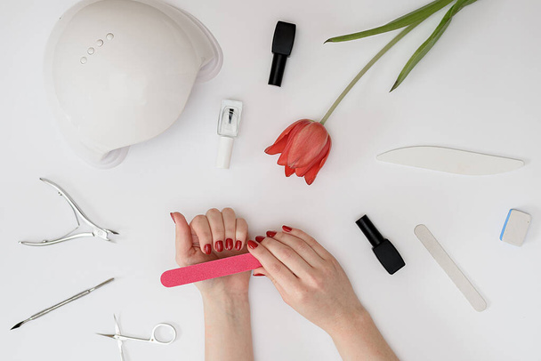 set for manicure neil art lay out tools for nail service on a white background female hand holding tool - Photo, Image