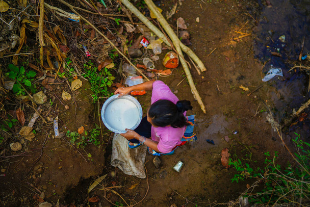 Mae Sariang, Tailândia - 25 de março de 2019: Mulher Karen tribal vista de cima trabalhando e transportando tigela com líquido branco no norte da Tailândia - Foto, Imagem