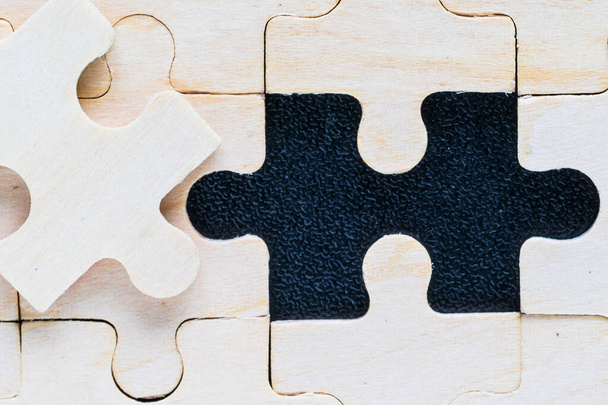 Close up Shot of wooden jigsaw puzzle pieces on black background,Business concept - Photo, Image