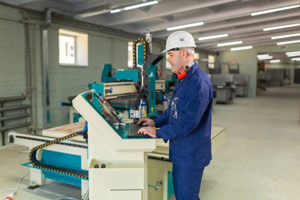 Worker in the Hard Hat Modern Factory CNC machine operator  . Successful, Handsome Man in Modern Industrial Environment.Emotions, Copy Space - Photo, Image