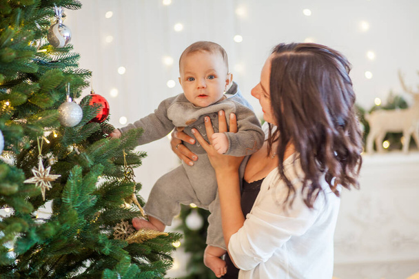 young mother with her son near the Christmas tree at home - Photo, Image