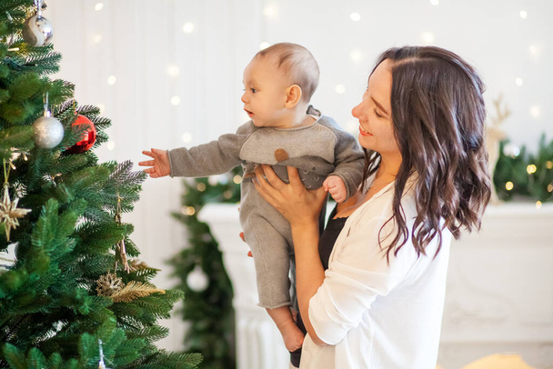 young mother with her son near the Christmas tree at home - Foto, Imagen