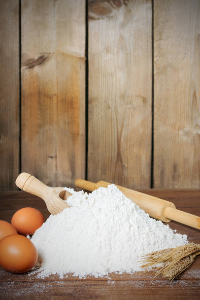 αλεύρι, κουτάλι, αυγά και ρολό σε ξύλινο φόντο - τροφίμων - Φωτογραφία, εικόνα