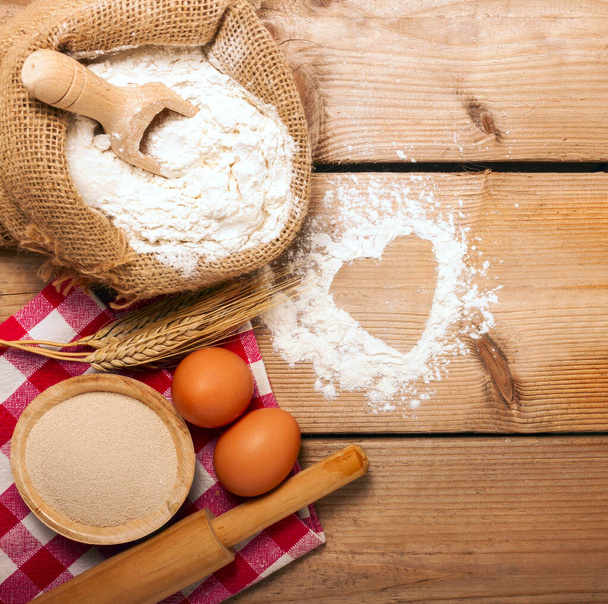 Mehl, Löffel, Eier und Walze auf Holzgrund - Lebensmittel - Foto, Bild