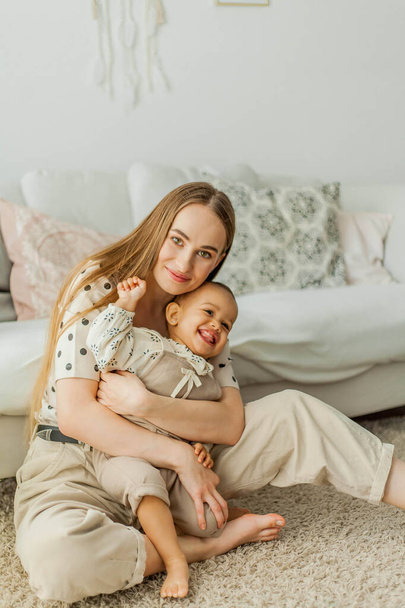 Happy mom and mulatto girl in home interior. Mothers Day. Baby. - Photo, image