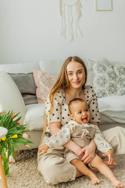 Happy mom and mulatto girl in home interior. Mothers Day. Baby. - Foto, imagen
