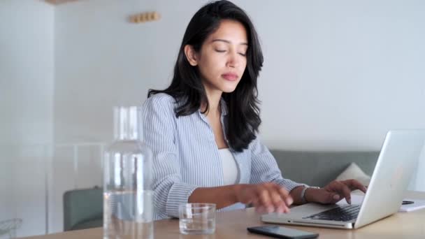 Vidéo d'une élégante jeune femme d'affaires recevant un message téléphonique tout en travaillant avec un ordinateur au bureau
. - Séquence, vidéo