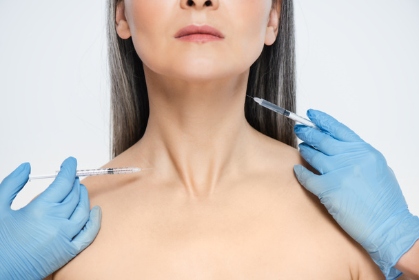 cropped view of nude asian woman and doctors in latex gloves holding syringes with beauty injections isolated on grey - Photo, Image
