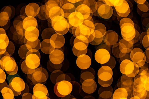Abstract oranje bokeh textuur op zwarte achtergrond - Foto, afbeelding