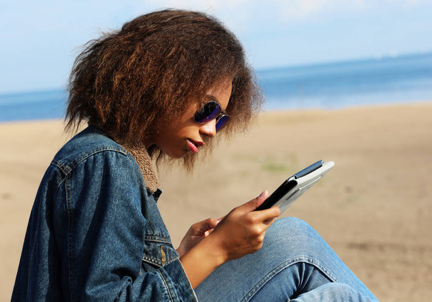 African american young woman with tablet on the beach - Fotografie, Obrázek
