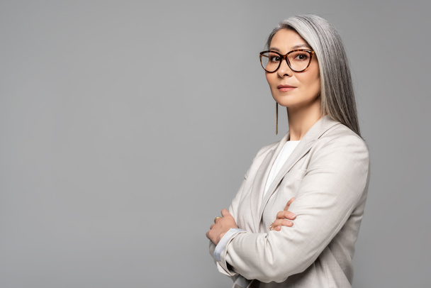 attrayant asiatique femme d'affaires dans des lunettes avec les bras croisés isolé sur gris
 - Photo, image