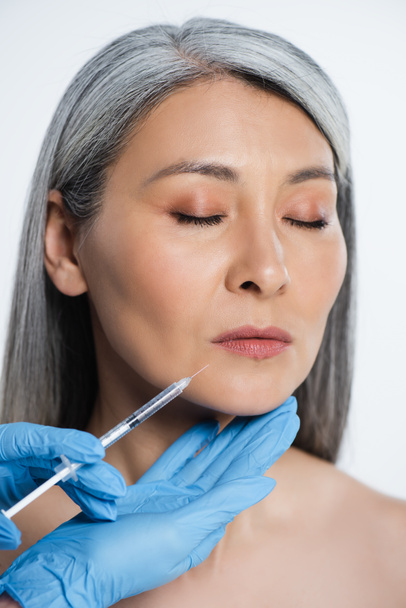 beautiful naked asian woman and doctor in latex gloves holding syringe with beauty injection isolated on grey - Foto, Imagen