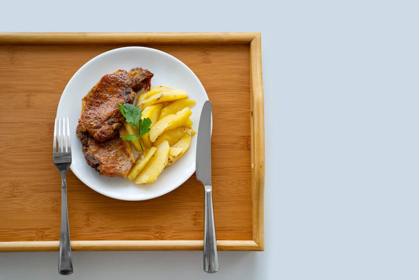 vlees en aardappelen op een wit bord. thuis koken.  - Foto, afbeelding