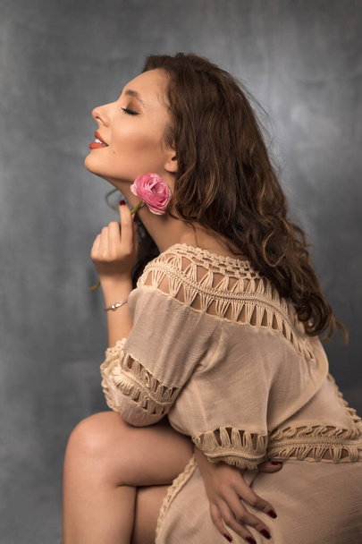 Retrato de jovem com bela maquiagem profissional e flor em fundo cinza
 - Foto, Imagem