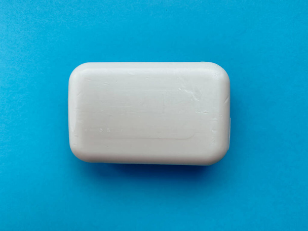 Solid soap for hands on a blue background. Hygiene and care. - Foto, afbeelding