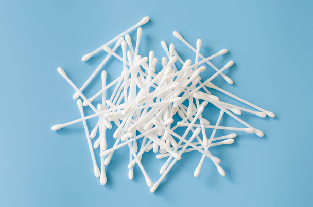 Cosmetic cotton buds on blue background. Sticks for cleaning ears. Top view. - Foto, immagini