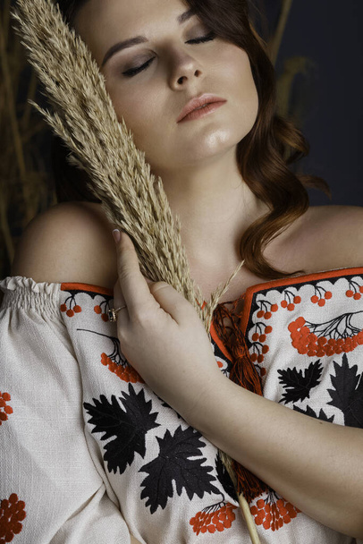 Ukrainian girl embroidered dress hay - Foto, afbeelding