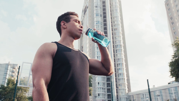 Laag zicht op sporter met gesloten ogen drinkwater op straat - Video