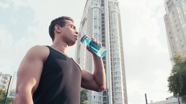 Tiefer Blickwinkel auf Sportler mit geschlossenen Augen, die Wasser trinken  - Filmmaterial, Video