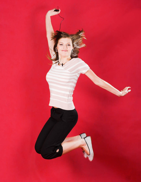 girl jumping of joy over red - Foto, Imagem