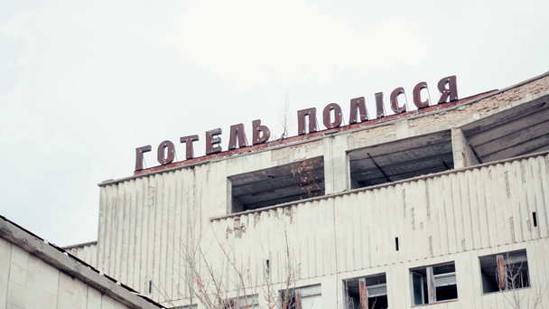 CHERNOBYL UKRAINE - NOVEMBER 6, 2019: alacsony látószögű kilátás elhagyott épület hotel polissya felirattal  - Felvétel, videó