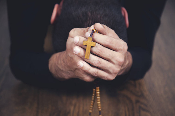 Modlitwa człowiek ręka krzyż na szarym tle wll - Zdjęcie, obraz