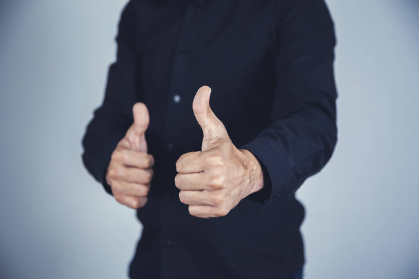 férfi ujj hüvelykujj a szürke fal háttér - Fotó, kép