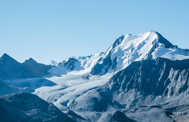 Vista panorámica de la montaña. Paisaje encantador con cielo azul, picos de nieve, rocas altas y glaciares
. - Foto, imagen