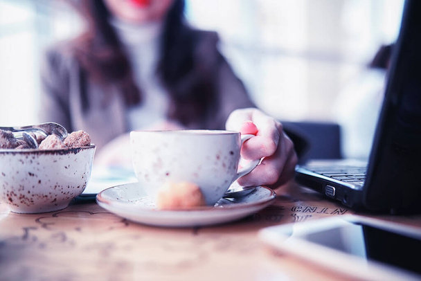 Κορίτσι τρώει κέικ καφέ και πίνει καφέ - Φωτογραφία, εικόνα