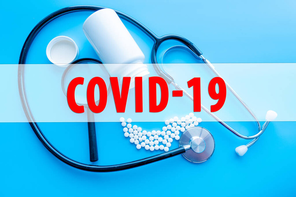 COVID-19 tekst ze stetoskopem i probówką krwi na czarnym tle. Koncepcja Covid-19 lub Coronavirus - Zdjęcie, obraz