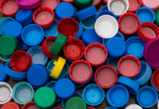 крупным планом большого количества разноцветных пластиковых крышек для бутылок
 - Фото, изображение