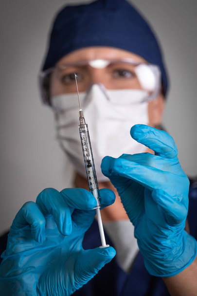 Arts of verpleegkundige die een medische spuit met naald vasthoudt. - Foto, afbeelding