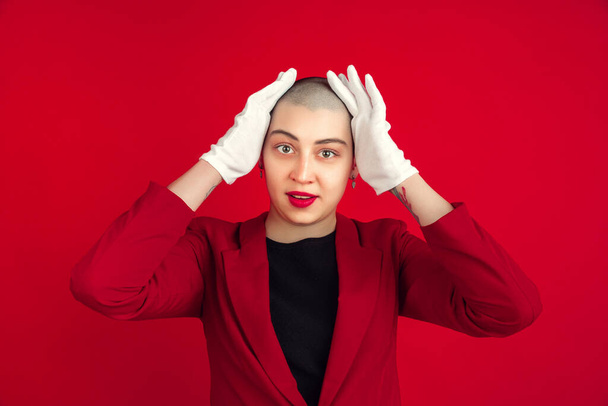 Portrait of young caucasian bald woman on red background - Foto, Imagen