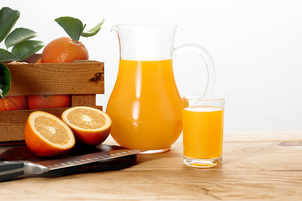 Pitcher και ένα ποτήρι χυμό πορτοκαλιού με φρέσκα πορτοκάλια. - Φωτογραφία, εικόνα