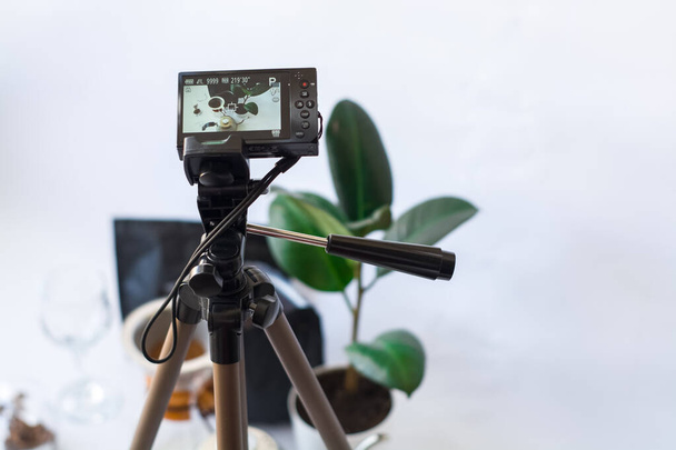 Aufnahme von Video mit der Kamera auf Stativ der Kaffeezubereitung auf weißem Hintergrund. - Foto, Bild