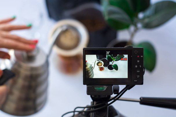Nahrávání videa na kameru na stativu procesu přípravy kávy na bílém pozadí. - Fotografie, Obrázek