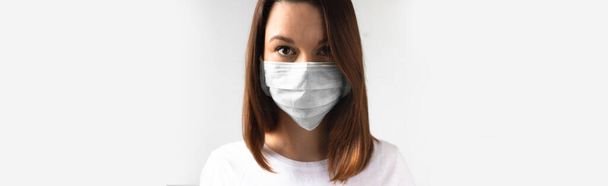 Coronavirus käsite. Tytöllä on lääketieteellinen naamio. Suojele terveyttäsi. Pysäyttäkää virus ja pandemia. Vaaleanharmaa tausta. Bannerin muoto
 - Valokuva, kuva