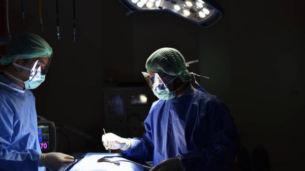 chirurgen in operatiekamer nemen met kunstlicht en zacht licht - Foto, afbeelding
