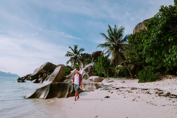 Ла Діг "ю Сейшельські острови, юнаки, які гуляють біля білого пляжу з ясним блакитним океаном у відпустці на тропічному острові. - Фото, зображення