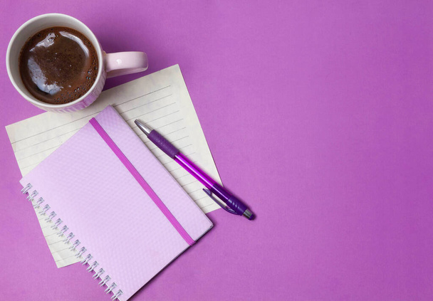 coffee, notebook and pen on a lilac background - Valokuva, kuva