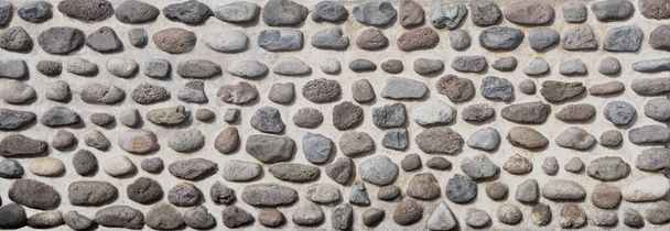 Oblázková kamenná zeď textura pozadí. Cementová omítka zdobená velkými přírodními oblázkovými kameny. Výzdoba fasády budovy - Fotografie, Obrázek