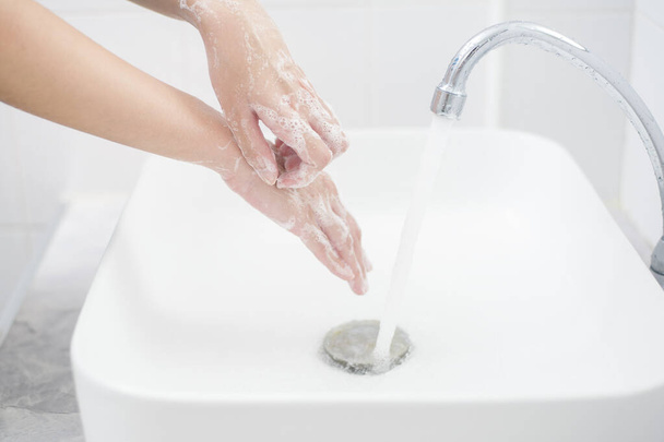 A woman is washing hands  - Foto, Bild