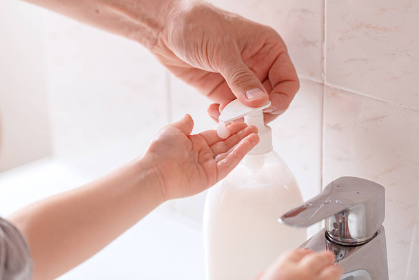 Father helps wash his little son's hands with soap on faucet. Close-up. Anti coronavirus prevention measures. covid-19 - Photo, image