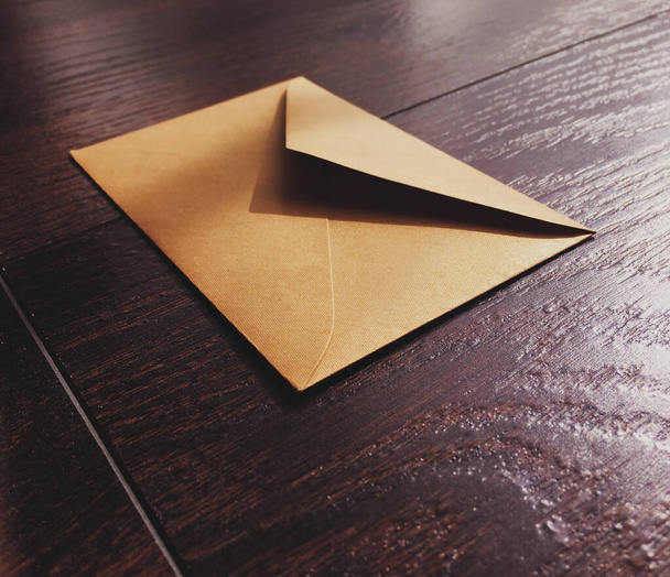 Golden vintage envelope on wooden background, newsletter and message - Foto, immagini