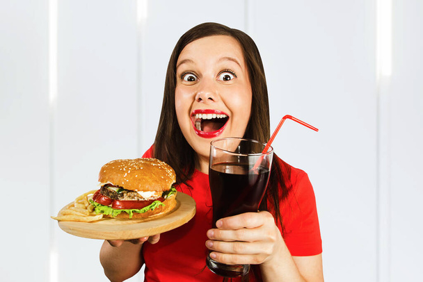 Portrait of beautiful girl hold fast food burger and drink cola. - Foto, Imagem