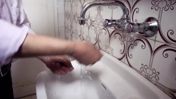 Très vieil homme turc qui nettoie les têtes de robinet après s'être lavé les mains dans sa salle de bain vintage
 - Séquence, vidéo