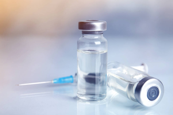 Vials and syringe on light table. Vaccination and immunization - Foto, Bild