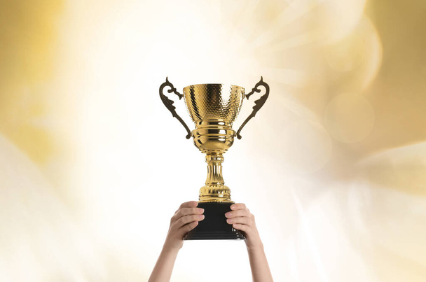 Femme tenant tasse trophée d'or sur fond de couleur, gros plan
 - Photo, image