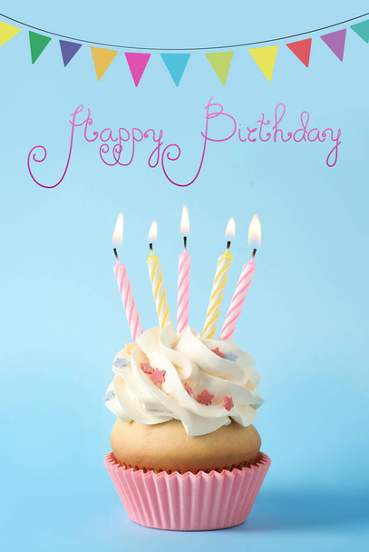 Text Happy Birthday, delicious cupcake with candles and party decor on light blue background - Фото, зображення